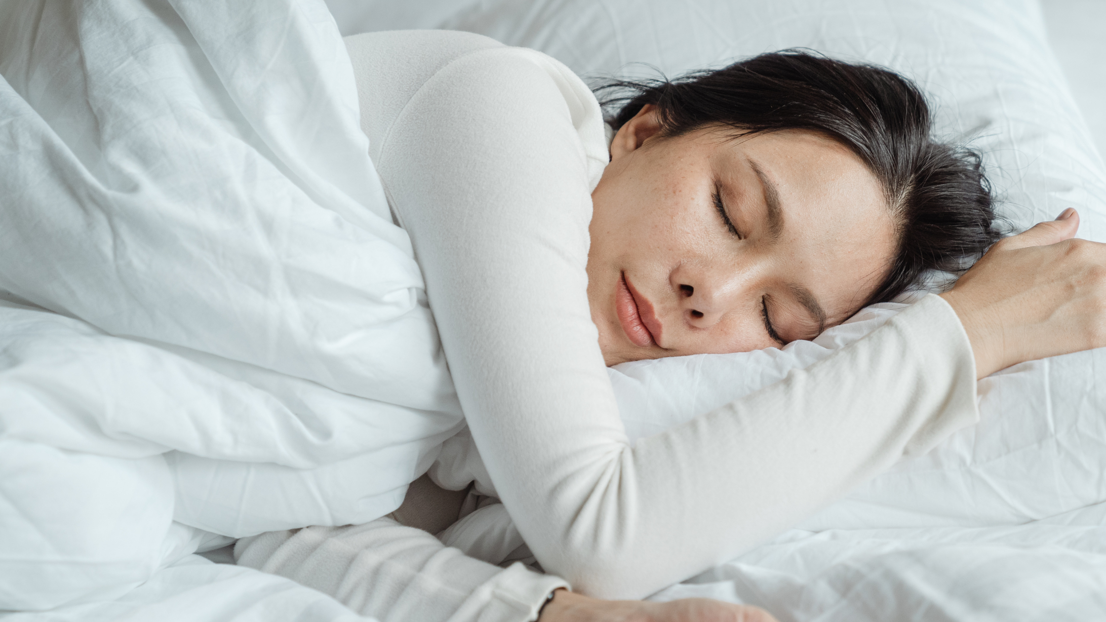 Woman sleeping on a white bed